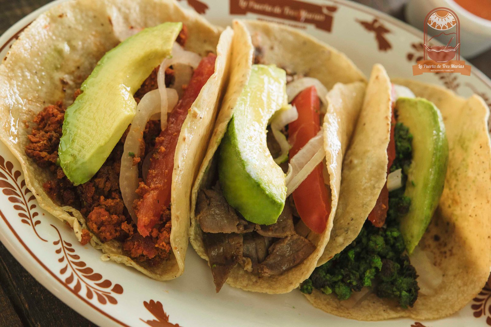 Tacos de la casa servidos con aguacate