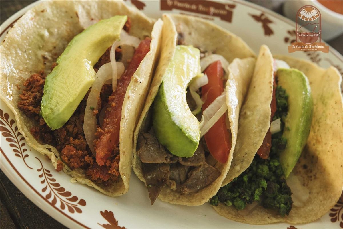 Tacos de la casa servidos con aguacate
